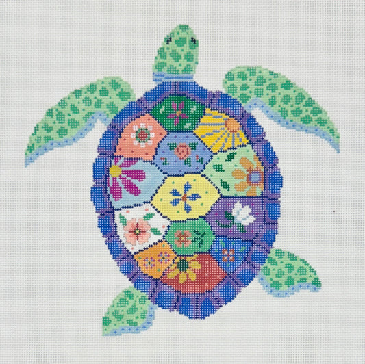 Susan Roberts needlepoint canvas of a sea turtle design with a blue-purple shell patterned with floral segments and green flippers and head on a white background.